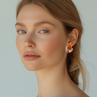 Woman wearing statement earrings with rectangular orange carnelian cabochon stones and clusters of clear marquise and oval crystals - Anton Heunis Handmade Jewelry