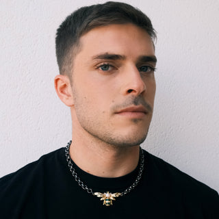 Man wearing a golden bee necklace with black chain - Anton Heunis