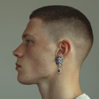 Man wearing black lion head statement earrings with emerald green drop - Anton Heunis