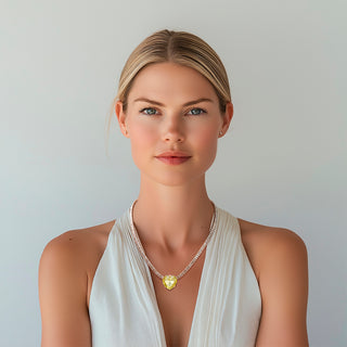 Woman wearing yellow crystal heart necklace with crystal cubic zirconia chain - Anton Heunis